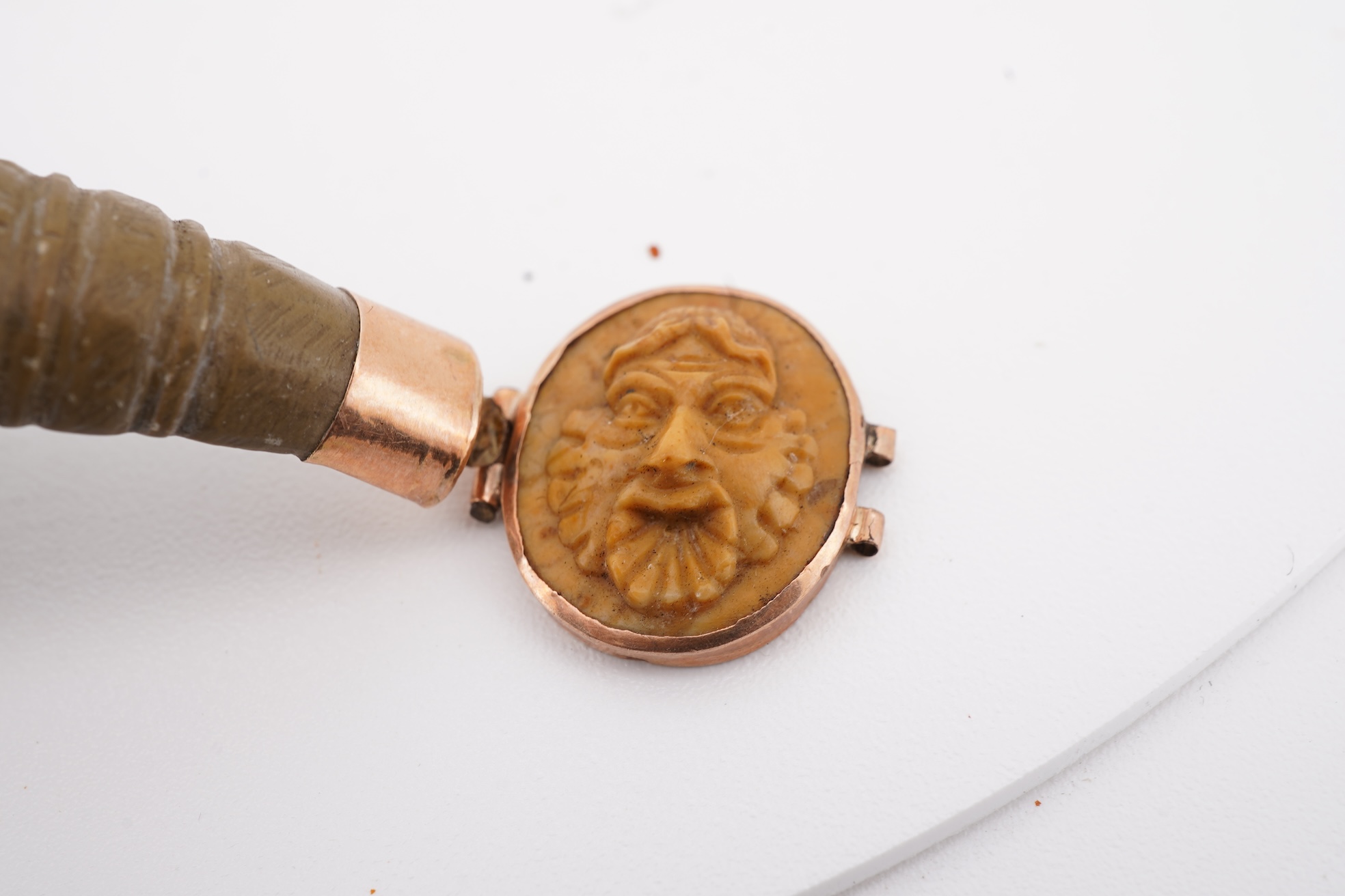 A collection of carved lava fragments, 19th century, once forming a bangle, the fragments variously carved with abstract floral motifs, lion's heads, and a theatrical mask, largest 6.2cm, Condition: fragmentary, but carv